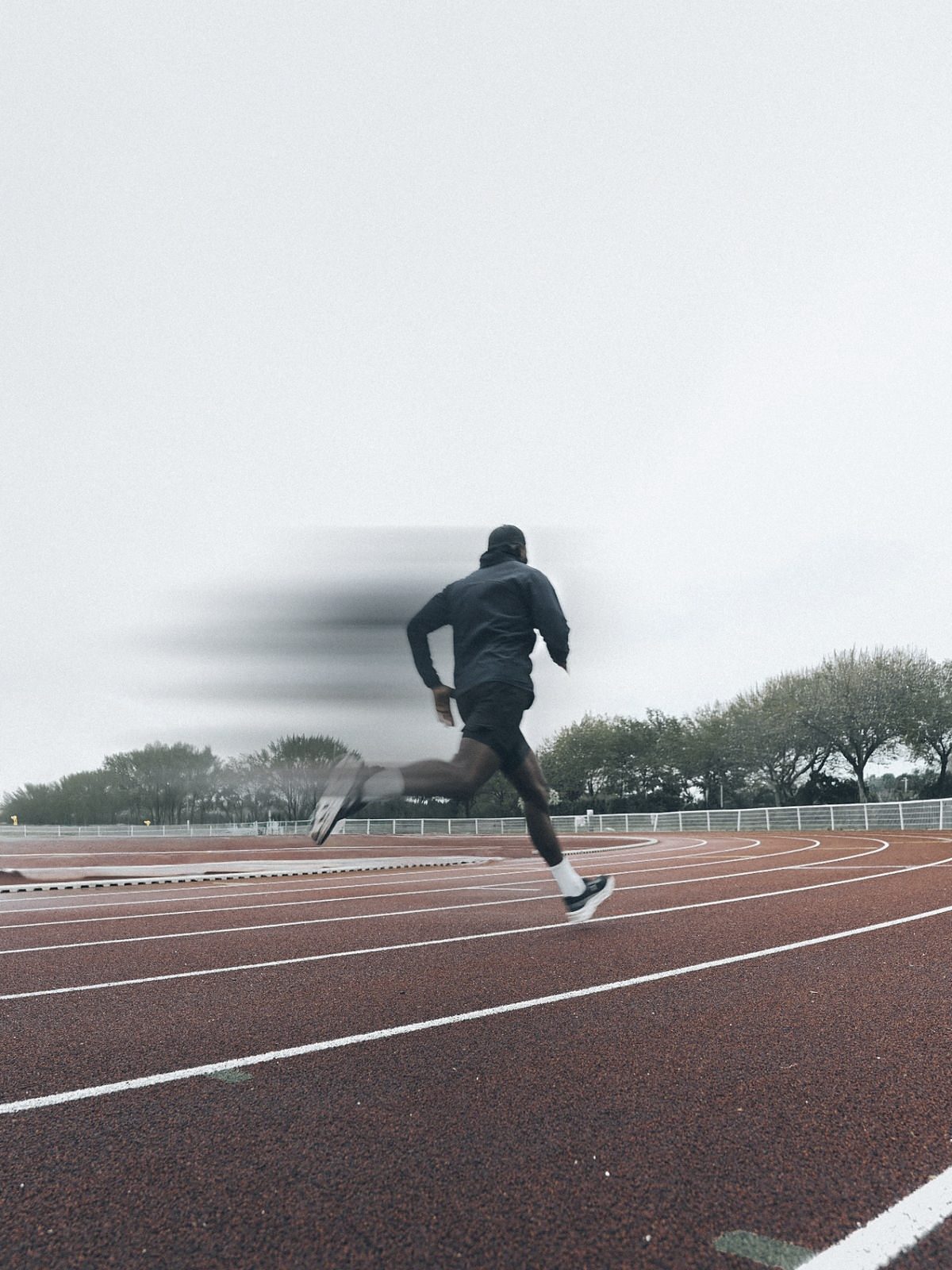 Athlète FORGER en sprint sur piste, sous la pluie